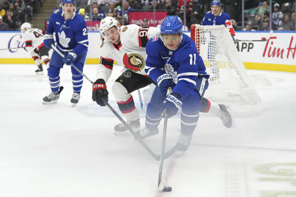 Toronto Maple Leafs' Max Domi, right, clears the puck away from Ottawa Senators' Vladimir Tarasenko during the first period of an NHL hockey game in Toronto, on Wednesday, Nov. 8, 2023. (Chris Young/The Canadian Press via AP)