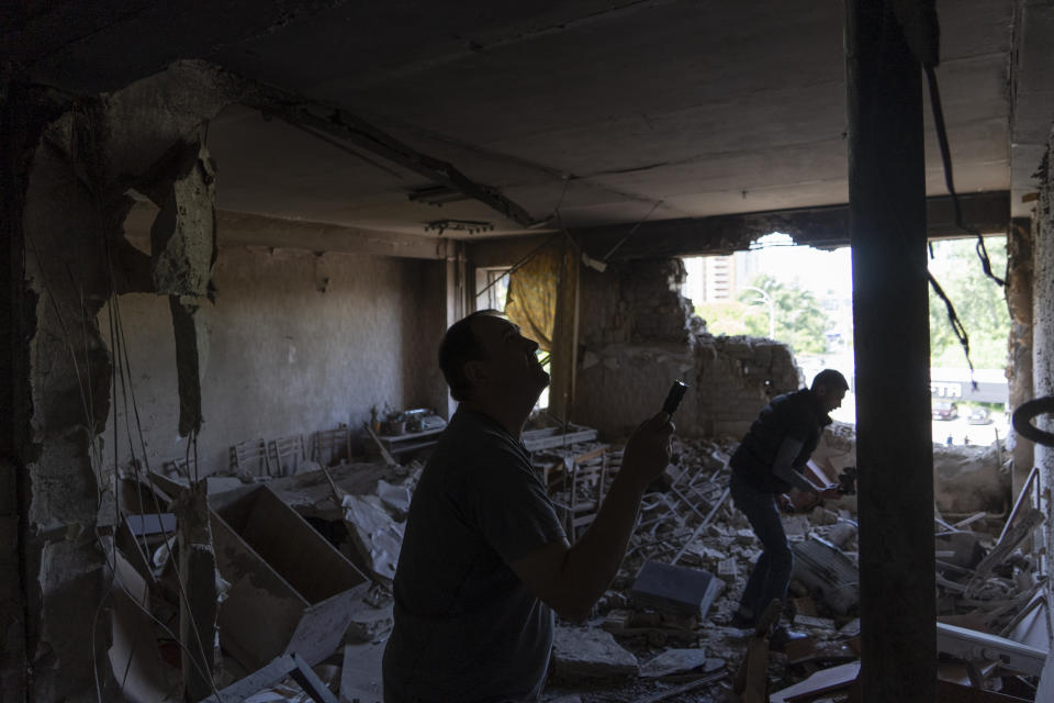 Men inspect their office damaged by a drone during a night attack, in Kyiv, Ukraine, Sunday, May 28, 2023. Ukraine's capital was subjected to the largest drone attack since the start of Russia's war, local officials said, as Kyiv prepared to mark the anniversary of its founding on Sunday. (AP Photo/Vasilisa Stepanenko)