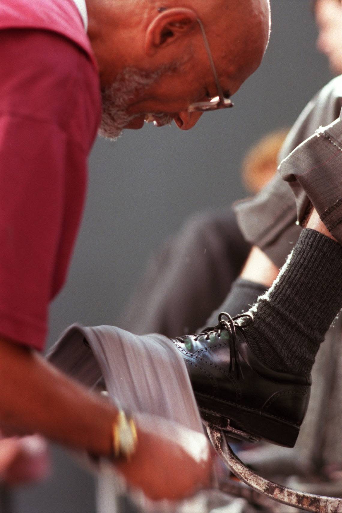 Isaac Bryant putts a shine on a customer’s shoes with a buffing cloth at Superior Shine inside the old Terminal A at Raleigh-Durham International Airport, in this file photo from 1998. Robert Willett/rwillett@newsobserver.com
