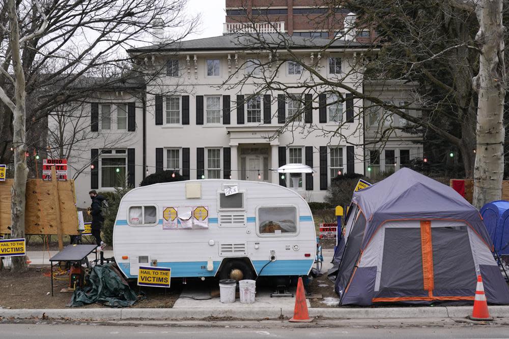 A camper and tent are shown outside the University of Michigan’s Presidents House on campus in Ann Arbor, Mich., Thursday, Jan. 20, 2022. (AP Photo/Paul Sancya)