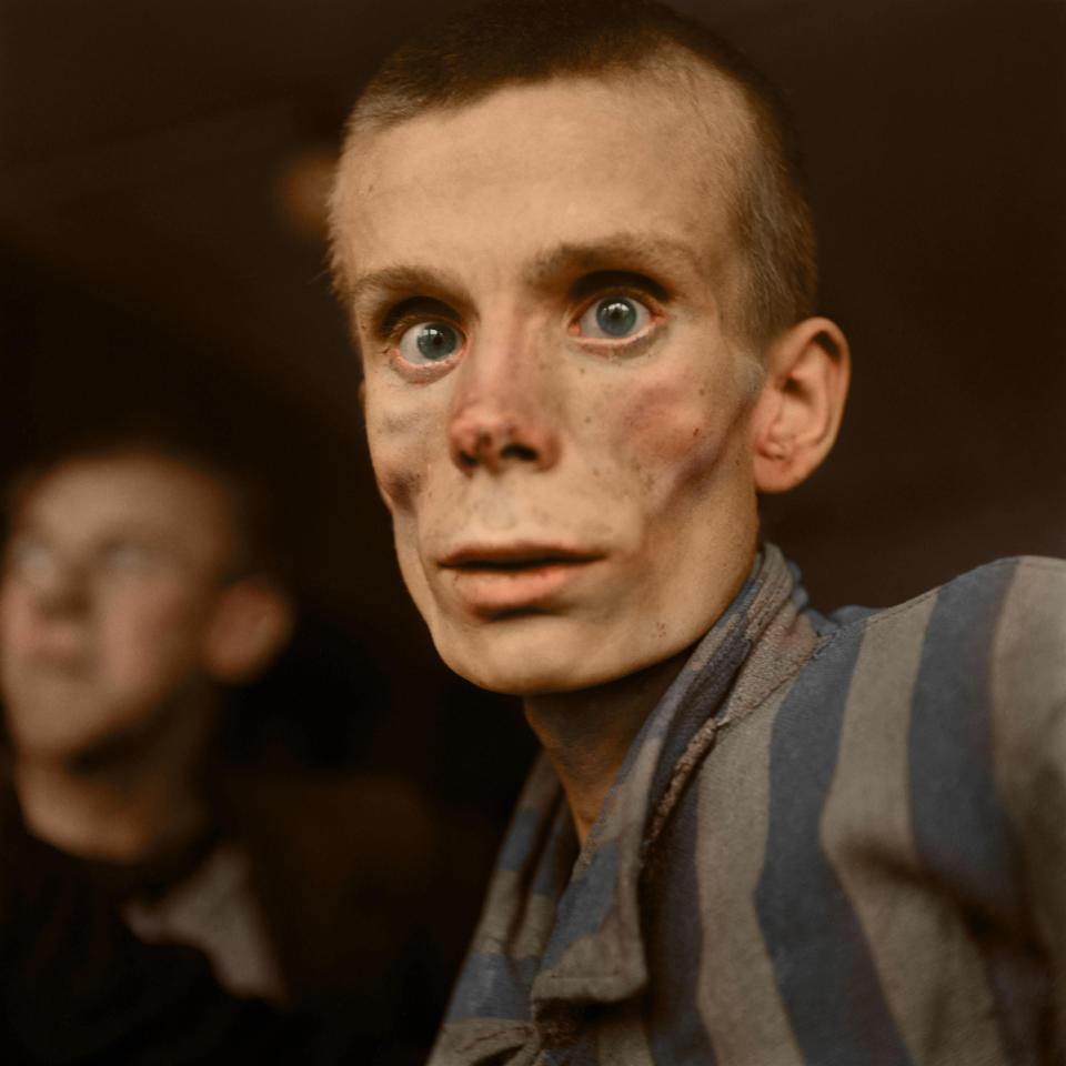 An emaciated 18-year-old Russian girl looks into the camera lens during the liberation of Dachau concentration camp in 1945. Dachau was the first German concentration camp, opened in 1933. More than 200,000 people were detained between 1933 and 1945, and 31,591 deaths were declared, most from disease, malnutrition and suicide. Unlike Auschwitz, Dachau was not explicitly an extermination camp, but conditions were so horrific that hundreds died every week. HARROWING colourised images of the Holocaust which expose the full terrors faced by the death camp?s inmates have emerged SEVENTY-FIVE-YEARS after the liberation of Auschwitz, the largest Nazi death camp. Sobering photos, some revamped in colour for the first time, capture the horror of genocide in the eyes of a gaunt 18-year-old Russian woman; a concentration camp responsible for the deaths of tens of thousands of innocent people being ceremonially burnt to the ground by liberating British forces; and malnourished Jewish children peering out at their Soviet rescuers through a barbed wire fence at Auschwitz. Other upsetting colourisations include a smiling portrait of four-year-old, Istvan Reiner, taken just a few weeks before he was murdered at the infamous death camp, and another showing a palpably relieved young Jewish refuge recuperating in hospital after being rescued by appalled Allied Forces. Mediadrumimages/TomMarshall(PhotograFix)2020