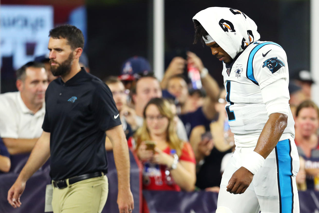 Cam Newton exits the field after suffering a foot injury against the Patriots. (Getty Images)