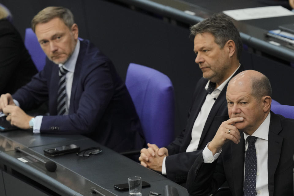 From right, German Chancellor Olaf Scholz, Economy and Climate Minister Robert Habeck and Finance Minister Christian Lindner listen to a debate about Germany's budget crisis at the parliament Bundestag in Berlin, Germany, Tuesday, Nov. 28, 2023. With its economy already struggling, Germany now is wrestling to find a way out of a budget crisis after a court struck down billions in funding for clean energy projects and help for people facing high energy bills because of Russia's war in Ukraine. (AP Photo/Markus Schreiber)