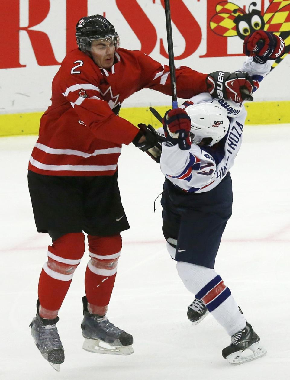 Canada's Adam Pelech (L) checks United States' Vince Hinostroza during the third period of their IIHF World Junior Championship ice hockey game in Malmo, Sweden, December 31, 2013. REUTERS/Alexander Demianchuk (SWEDEN - Tags: SPORT ICE HOCKEY)