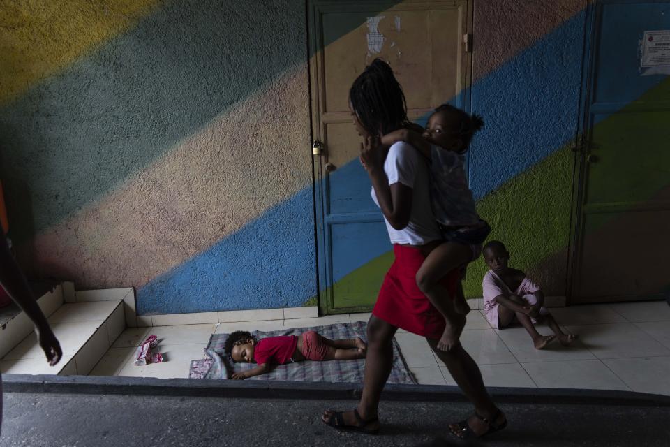 FILE - A child sleeps on a blanket spread out in a passageway of a gym converted into a shelter for people displaced by gang violence, in Port-au-Prince, Haiti, May 3, 2024. More than 360,000 have been left homeless by gang invasions, and basic supplies dwindled as the main seaport and international airport closed for months. (AP Photo/Ramon Espinosa, File)