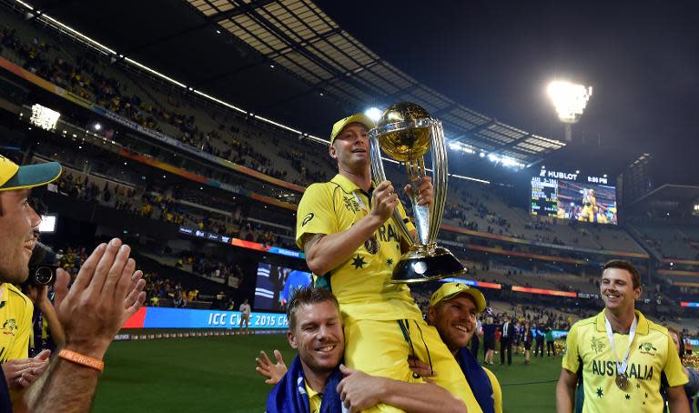 Michael Clarke holds the Cricket World Cup trophy while sitting on the shoulders of teammates Aaron Finch (2nd right) and David Warner