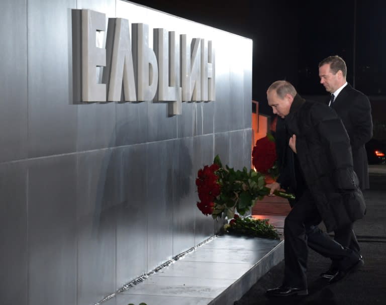 Russian President Vladimir Putin (front) and Prime Minister Dmitry Medvedev lay flowers at a monument to Boris Yeltsin in Yekaterinburg on November 25, 2015