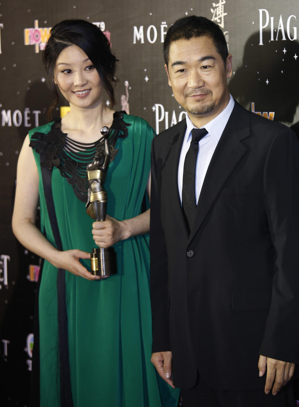 Chinese actors Zhang Guo-li, right, and Xu Fan pose after winning the Best Film From Mainland And Taiwan award for their movie 'Back To 1942' at the 32nd Hong Kong Film Awards in Hong Kong Saturday, April 13, 2013. (AP Photo/Vincent Yu)