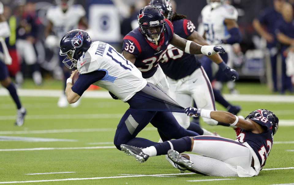 Houston Texans cornerback Vernon Hargreaves III (28) grabs the shirt of Tennessee Titans quarterback Ryan Tannehill (17) as he tries to tackle him during the first half of an NFL football game Sunday, Dec. 29, 2019, in Houston. (AP Photo/Michael Wyke)