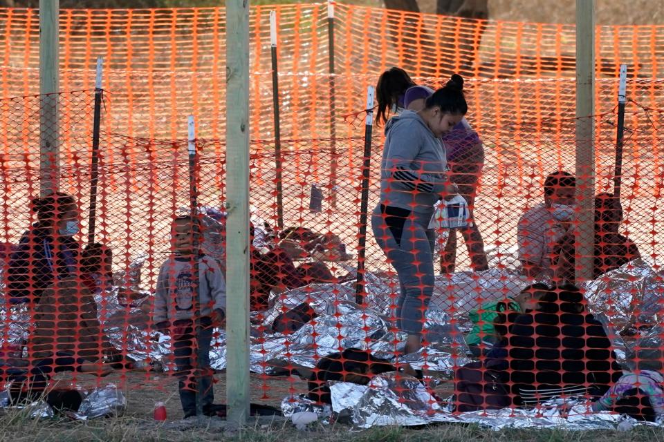 Migrants are seen in custody at a U.S. Customs and Border Protection processing area under the Anzalduas International Bridge, Friday, March 19, 2021, in Mission, Texas. A surge of migrants on the Southwest border has the Biden administration on the defensive. The head of Homeland Security acknowledged the severity of the problem Tuesday but insisted it's under control and said he won't revive a Trump-era practice of immediately expelling teens and children. An official says U.S. authorities encountered nearly double the number children traveling alone across the Mexican border in one day this week than on an average day last month. (AP Photo/Julio Cortez)