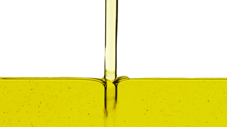 olive oil being poured with white background