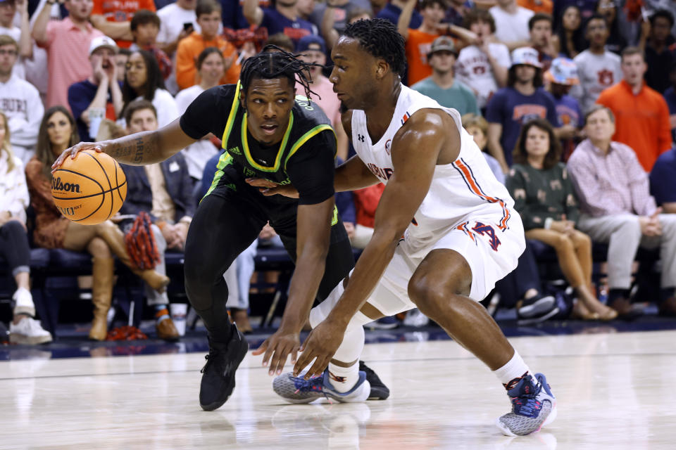South Florida guard Ryan Conwell, left, tries to dribble around Auburn forward Chris Moore during the first half of an NCAA college basketball game Friday, Nov. 11, 2022, in Auburn, Ala. (AP Photo/Butch Dill)