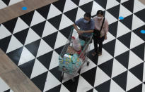 Shoppers wearing face masks to help curb the spread of the coronavirus push their shopping cart at shopping mall in Bangkok, Thailand, Friday, June 12, 2020. The Thai government continues to ease restrictions related to running business in capital Bangkok that were imposed weeks ago to combat the spread of COVID-19. (AP Photo/Sakchai Lalit)