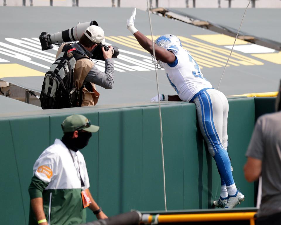 Detroit Lions running back Kerryon Johnson (33) celebrates a touchdown by jumping into the stands with no fans during the first quarter of the Green Bay Packers play the Detroit Lions at Lambeau Field in Green Bay on Sunday, Sept. 20, 2020.