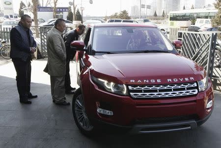 Customers look at a Range Rover Evoque car outside a dealership in Beijing in this February 17, 2012 file photo. REUTERS/Jason Lee/Files