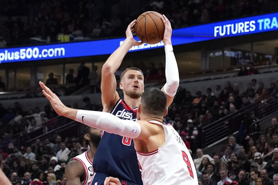 Washington Wizards' Kristaps Porzingis looks to shoot over Chicago Bulls' Nikola Vucevic during the second half of an NBA basketball game Wednesday, Dec. 7, 2022, in Chicago. The Bulls won 115-111. (AP Photo/Charles Rex Arbogast)