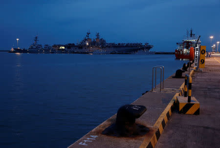 The damaged USS John McCain (L) is docked next to USS America at Changi Naval Base in Singapore August 22, 2017. REUTERS/Calvin Wong