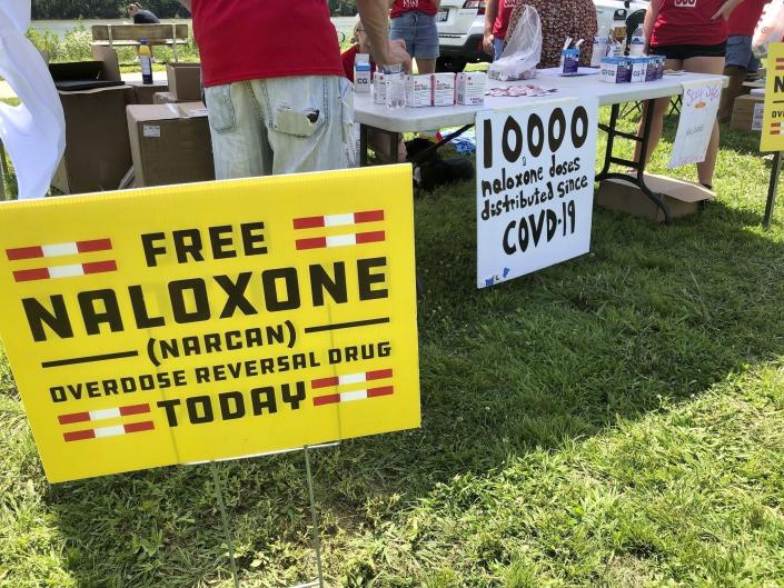FILE - Signs are displayed at a tent during a health event on June 26, 2021, in Charleston, W.Va. As the number of U.S. overdose deaths continues to soar, states are trying to take steps to combat a flood of the drug that has proved the most lethal -- illicitly produced fentanyl.(AP Photo/John Raby, File)