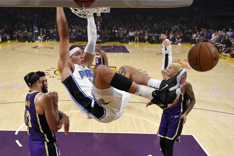 Orlando Magic forward Aaron Gordon, center, dunks as Los Angeles Lakers center JaVale McGee, left, and forward Kyle Kuzma, right, stand by during the first half of an NBA basketball game Wednesday, Jan. 15, 2020, in Los Angeles. (AP Photo/Mark J. Terrill)
