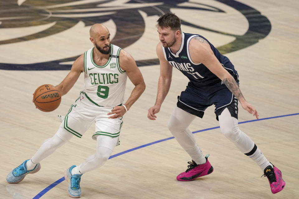 El base de los Celtics de Boston Derrick White avanza con el balón frente a Luka Doncic de los Mavericks de Dallas en el juego 3 de las Finales de la NBA el miércoles 12 de junio del 2024. (AP Foto/Sam Hodde)