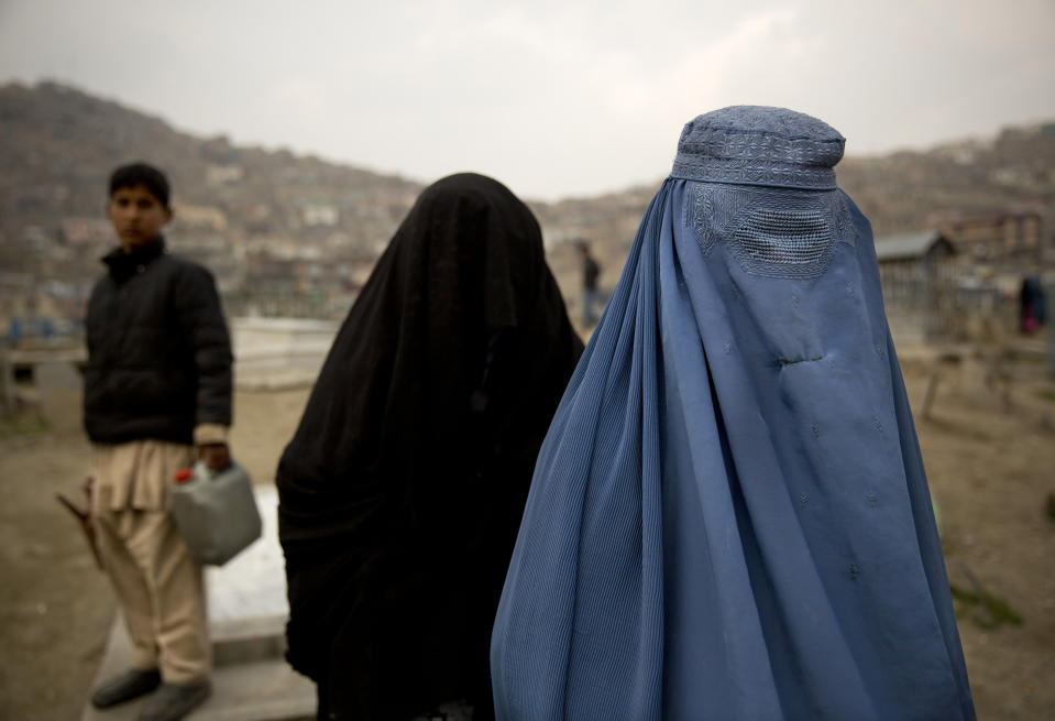 In this Friday, March 7, 2014 photo, Afghan women cross a cemetery in the center of Kabul, Afghanistan. A gender and development specialist and human rights activist, Afghan Wazhma Frogh says her experience characterizes the women’s rights movement in her country- after 12 years, billions of dollars and countless words emanating from the West commiserating with Afghan women, the successes are fragile, the changes superficial and vulnerable. (AP Photo/Anja Niedringhaus)