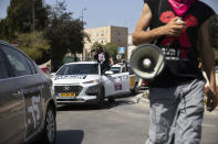 Israeli protesters demonstrate against a proposed measure to curtail public demonstrations during the current nationwide lockdown due to the coronavirus pandemic, in front of the Knesset, Israel's parliament in Jerusalem, Tuesday, Sept. 29, 2020. (AP Photo/Sebastian Scheiner)