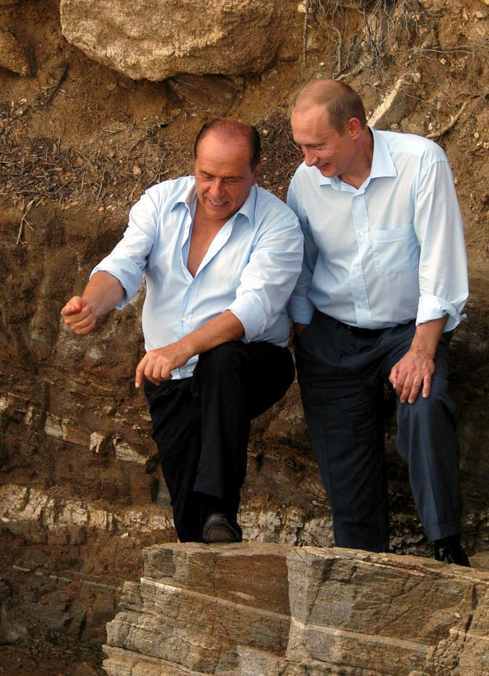 Berlusconi talks to Vladimir Putin while talking a walk at the Italian’s villa La Certosa in Sardinia, in 2003 (Reuters)