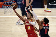 Atlanta Hawks guard Trae Young (11) lays in a bucket as Washington Wizards forward Rui Hachimura (8) defends during the first half of an NBA basketball game Wednesday, May 12, 2021, in Atlanta. (AP Photo/Butch Dill)