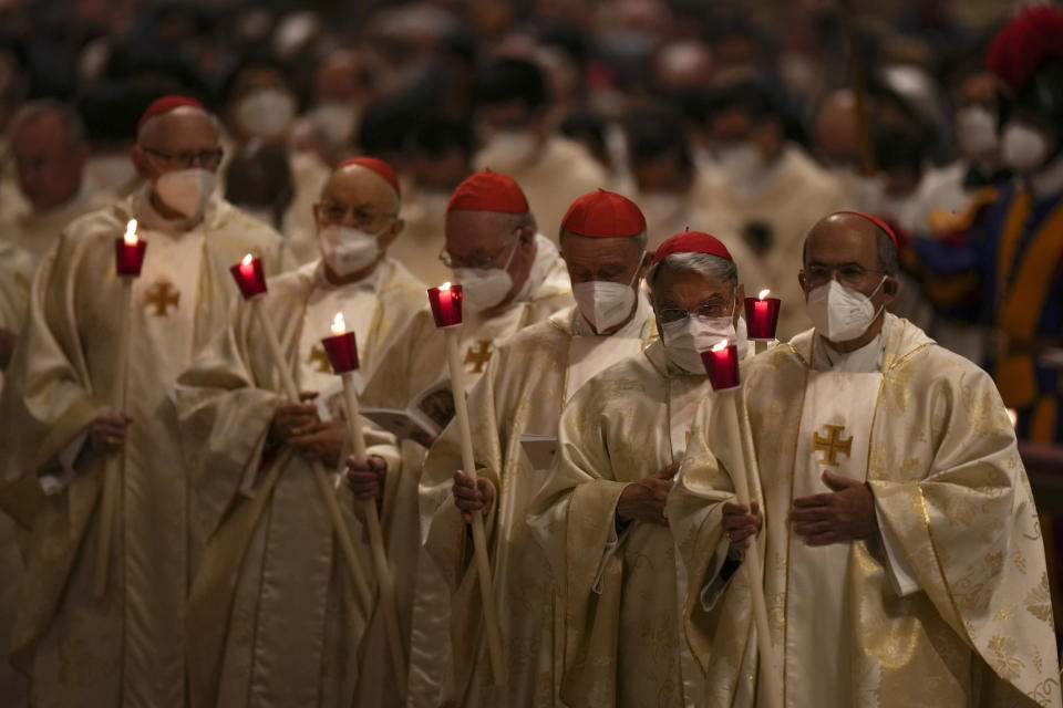 Cardinals hold Paschal candles during a Easter vigil ceremony in St. Peter's Basilica at the Vatican, Saturday, April 16, 2022. (AP Photo/Alessandra Tarantino)