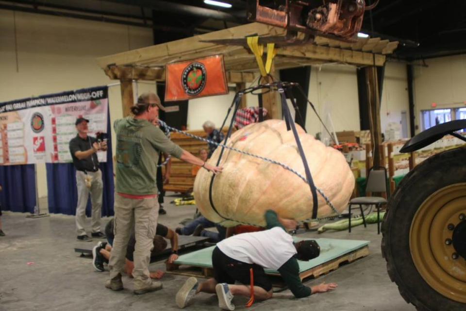 The record-setting pumpkin grown by Chris Rodebaugh of Lewisburg, West Virginia is lifted by a crane at the North Carolina State Fair on Wednesday, Oct. 13, 2021.