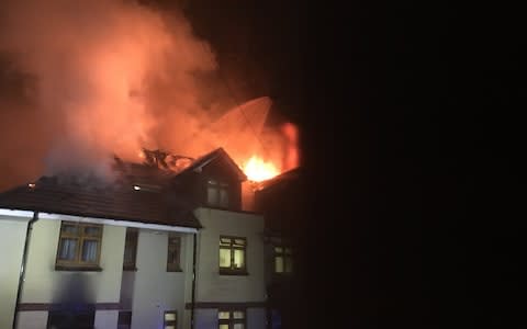 Pictures from the scene show flames pouring out of the roof of the building, which houses Connington Court and Connington House - Credit: Twitter/London Fire Brigade