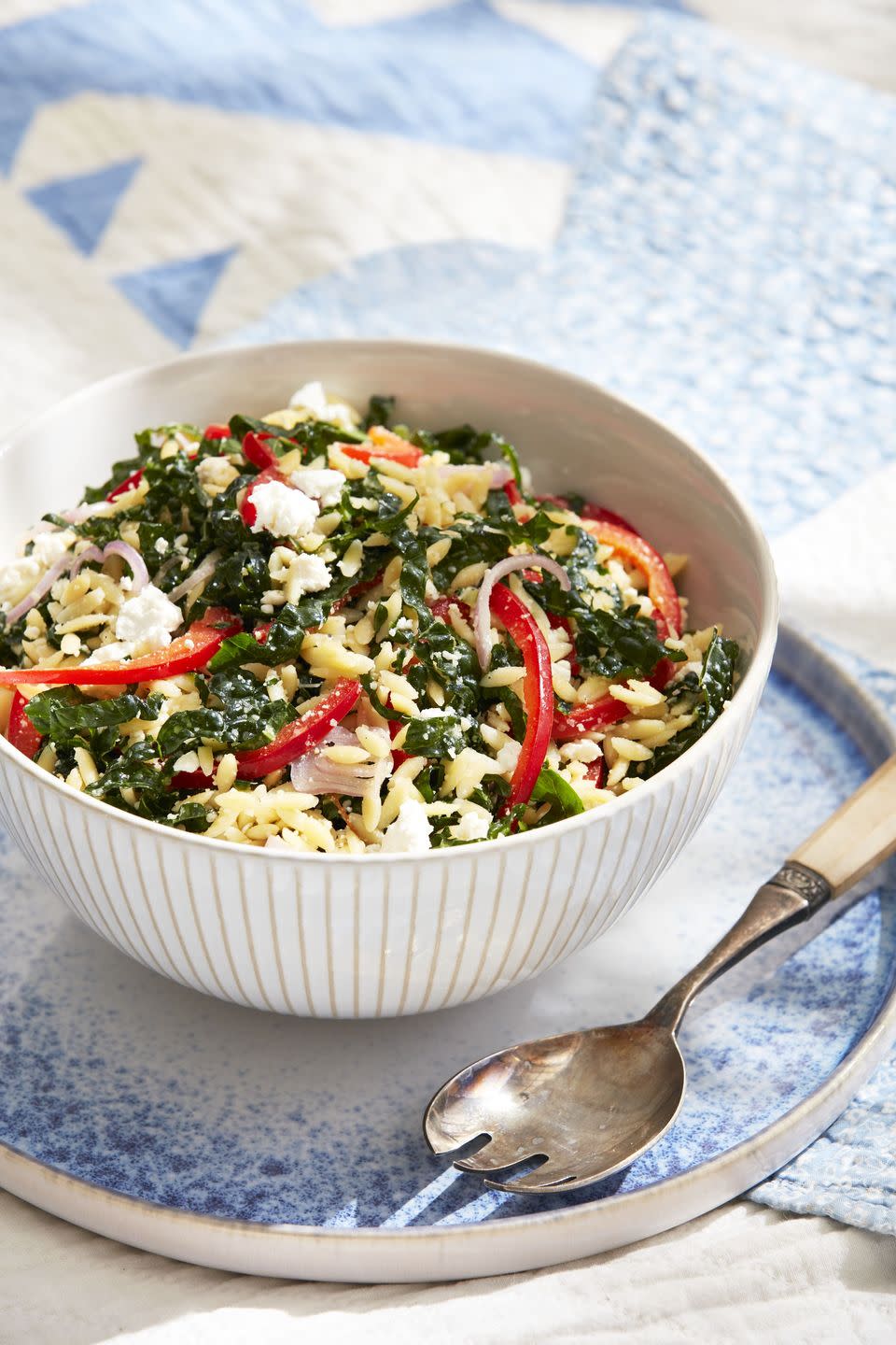 orzo pasta salad in a bowl with a spoon for serving