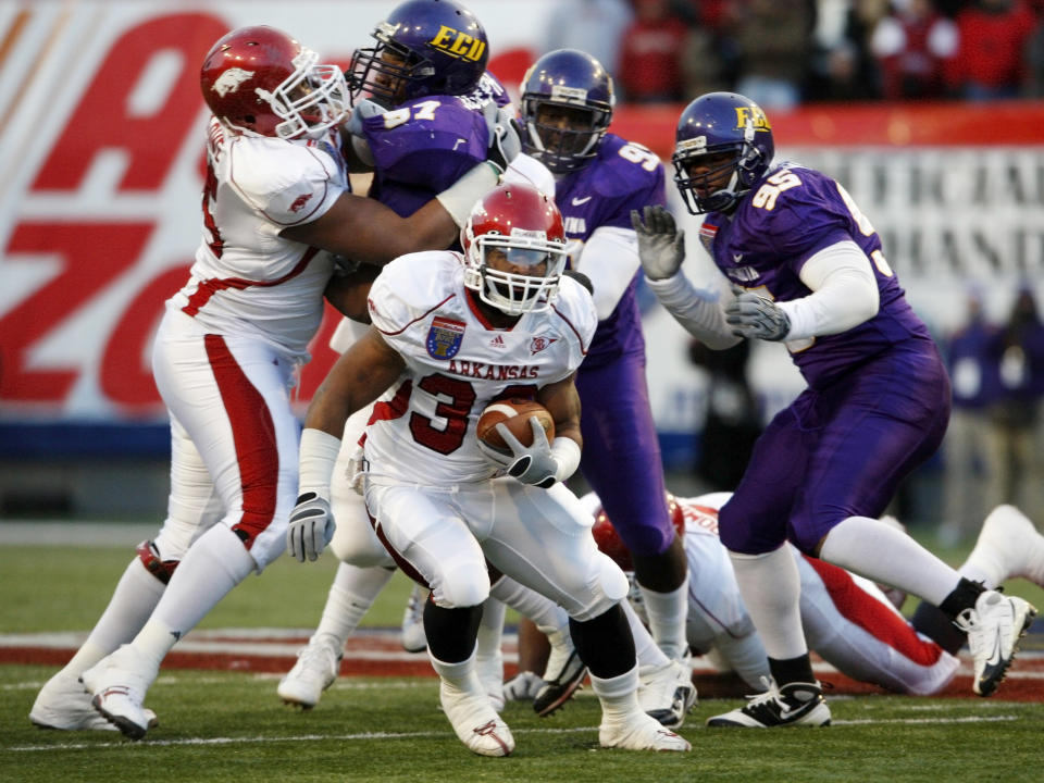 Arkansas running back Dennis Johnson (33) gets past East Carolina defenders Linval Joseph (97), Jay Ross (90), and C. J. Wilson (95) in the first quarter of the Liberty Bowl NCAA college football game on Saturday, Jan. 2, 2010, in Memphis, Tenn. Blocking for Johnson at left is DeMarcus Love. (AP Photo/Mark Humphrey)