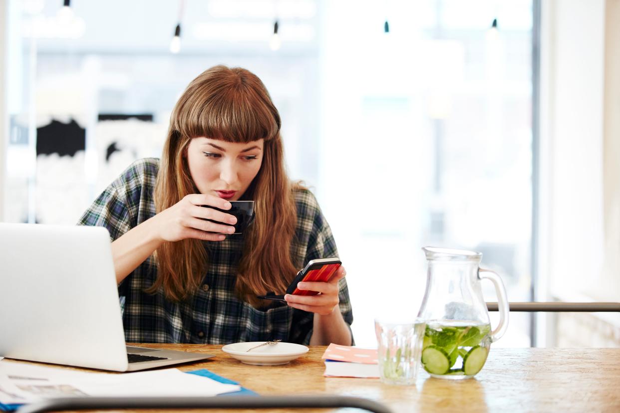 Girl drinking coffee, checking phone.