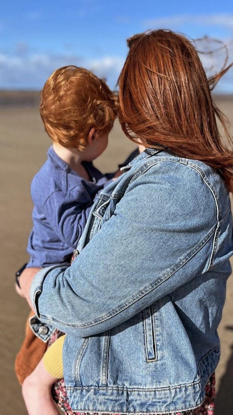 Woman holds a child on a beach