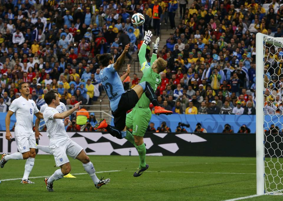 England's goalkeeper Hart makes a save next to Uruguay's Caceres during their 2014 World Cup Group D soccer match in Sao Paulo