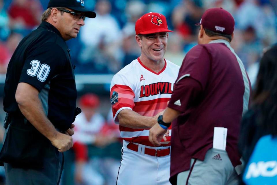 Jun 20, 2019; Omaha, NE, USA; Louisville Cardinals head coach Dan McDonnell greets Mississippi State Bulldogs head coach Chris Lemonis as home plate umpire Jeff Hinrichs looks on prior to the game in the 2019 College World Series at TD Ameritrade Park.