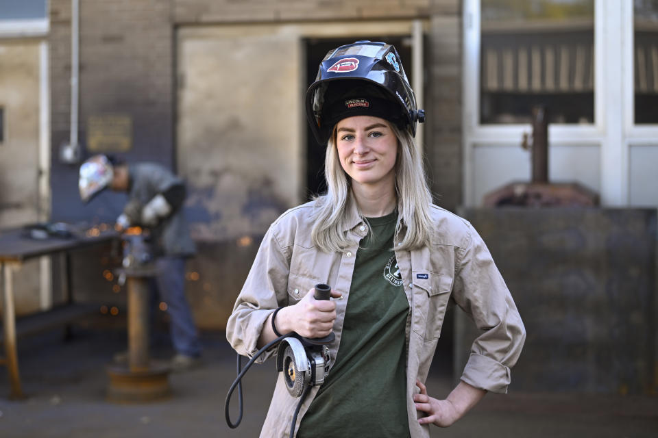 Tennessee College of Applied Technology Nashville student Abbey Carlson poses during welding class Wednesday, April 13, 2023, in Nashville, Tenn. While almost every sector of higher education is seeing fewer students registering for classes, many trade school programs are booming with young people who are choosing trade school over a traditional four-year degree. (AP Photo/John Amis)