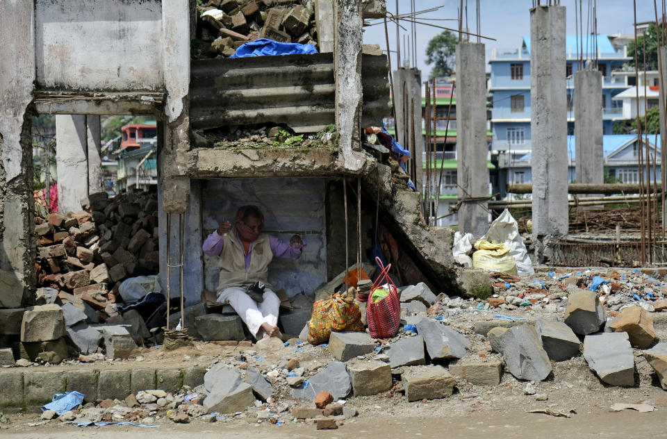 A cobbler covers his face with a scarf and works in the shade of a dilapidated building in Kohima, capital of the northeastern Indian state of Nagaland, Friday, May 29, 2020. India’s economic growth will fall to 4.2% in financial year 2019-20 as compared to 6.1% in the previous year and likely to contract this year because of the coronavirus pandemic. Millions of workers have fled cities after losing their jobs as authorities imposed the lockdown in March and started easing it early this month to promote economic activity. (AP Photo/Yirmiyan Arthur)