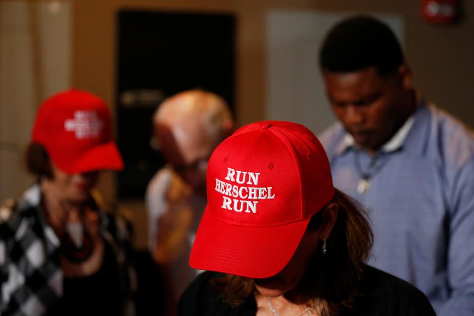 Herschel Walker and supporters prey before the start of a "Herschel for Senate" rally at the Foundry in Athens, Ga., on Monday, May 23, 2022. Walker chose Athens to hold his final rally before the Republican primary on May 24.