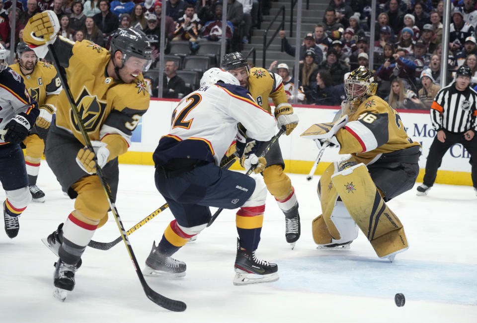 Colorado Avalanche left wing Artturi Lehkonen, second from left, tries to redirect the puck into the net as, from left, Vegas Golden Knights defensemen Brayden McNabb and Alex Pietrangelo aid goaltender Logan Thompson in the first period of an NHL hockey game, Monday, Jan. 2, 2023, in Denver. (AP Photo/David Zalubowski)