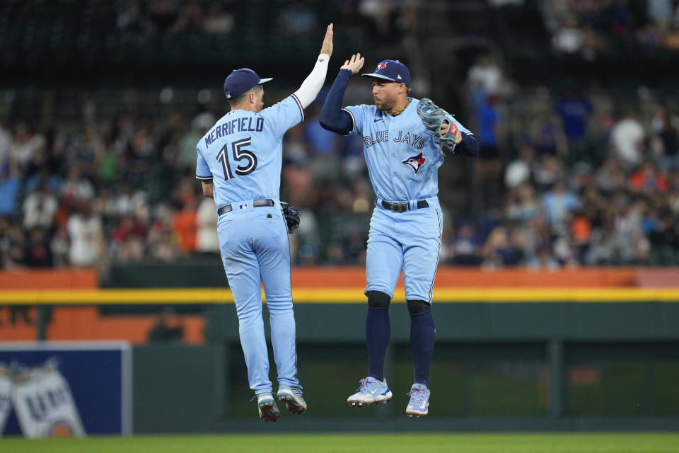 Toronto Blue Jays' Whit Merrifield (15) and George Springer (4) celebrate after beating the Detroit Tigers 12-2 in a baseball game, Friday, July 7, 2023, in Detroit. (AP Photo/Paul Sancya)