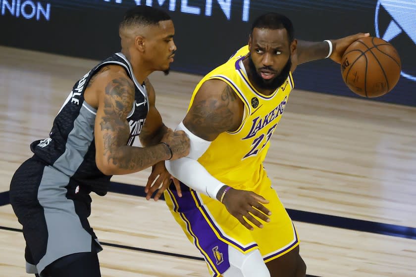 Sacramento Kings' DaQuan Jeffries, left, defends against Los Angeles Lakers' LeBron James.