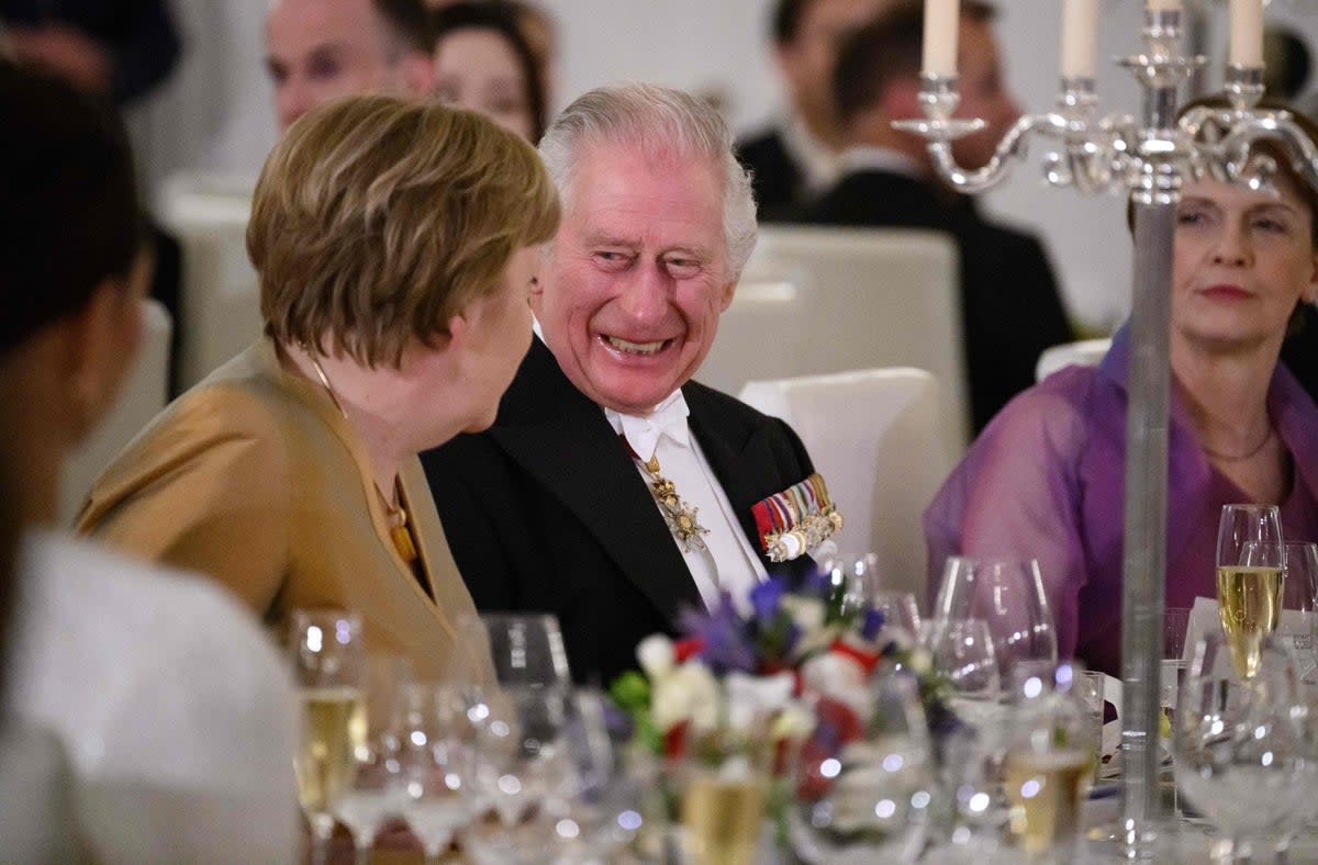 Charles sits next to former German chancellor Angela Merkel (pictured left) at the state banquet (POOL/AFP via Getty Images)