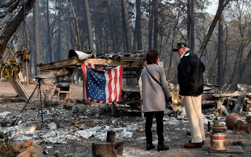 Donald Trump views the charred remains left behind after wildfires swept through Paradise, California - AFP