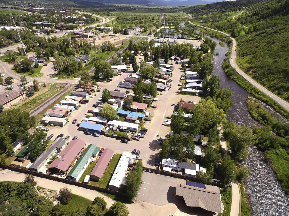 This July 6, 2019, photo shows the Fish Creek Mobile Home Park next to the Yampa River and bike path in Steamboat Springs, Colo. Some Colorado towns are taking action to preserve their remaining mobile home parks. Cities, counties and housing authorities, such as the Yampa Valley Housing Authority in Steamboat Springs, are buying mobile home parks to preserve affordable housing for residents as other mom-and-pop park owners sell out to developers or investors.(Matt Stensland/The Colorado Sun via AP)