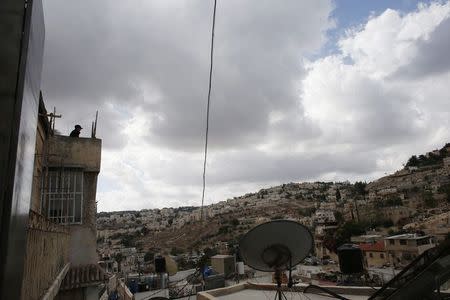 An Israeli guard stands on the roof of a house purchased by Jews in the mostly Arab neighbourhood of Silwan in east Jerusalem October 20, 2014. REUTERS/Ronen Zvulun