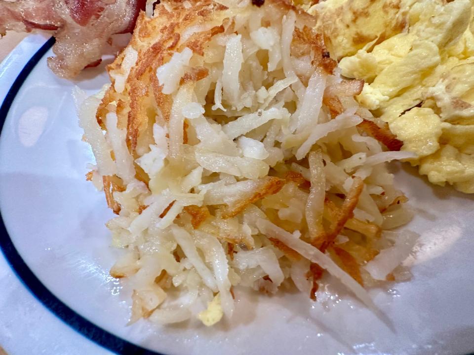 hash browns on white plate beside eggs at ihop