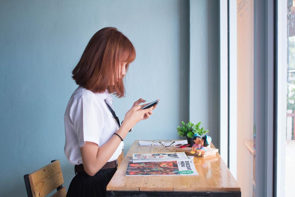 Woman at window with phone