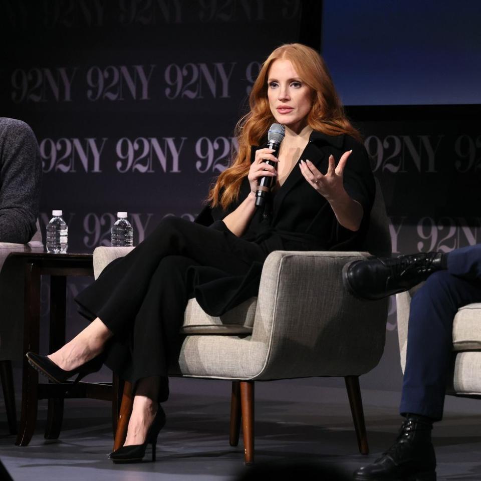 a woman sitting on a chair holding a microphone